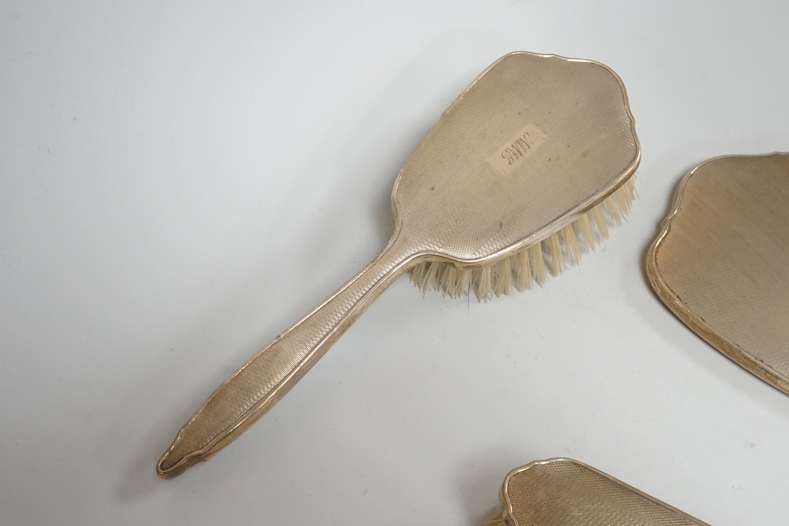 An early 1960's silver mounted hand mirror, 24.7cm and two matching brushes, Adie Bros. Birmingham, 1960.